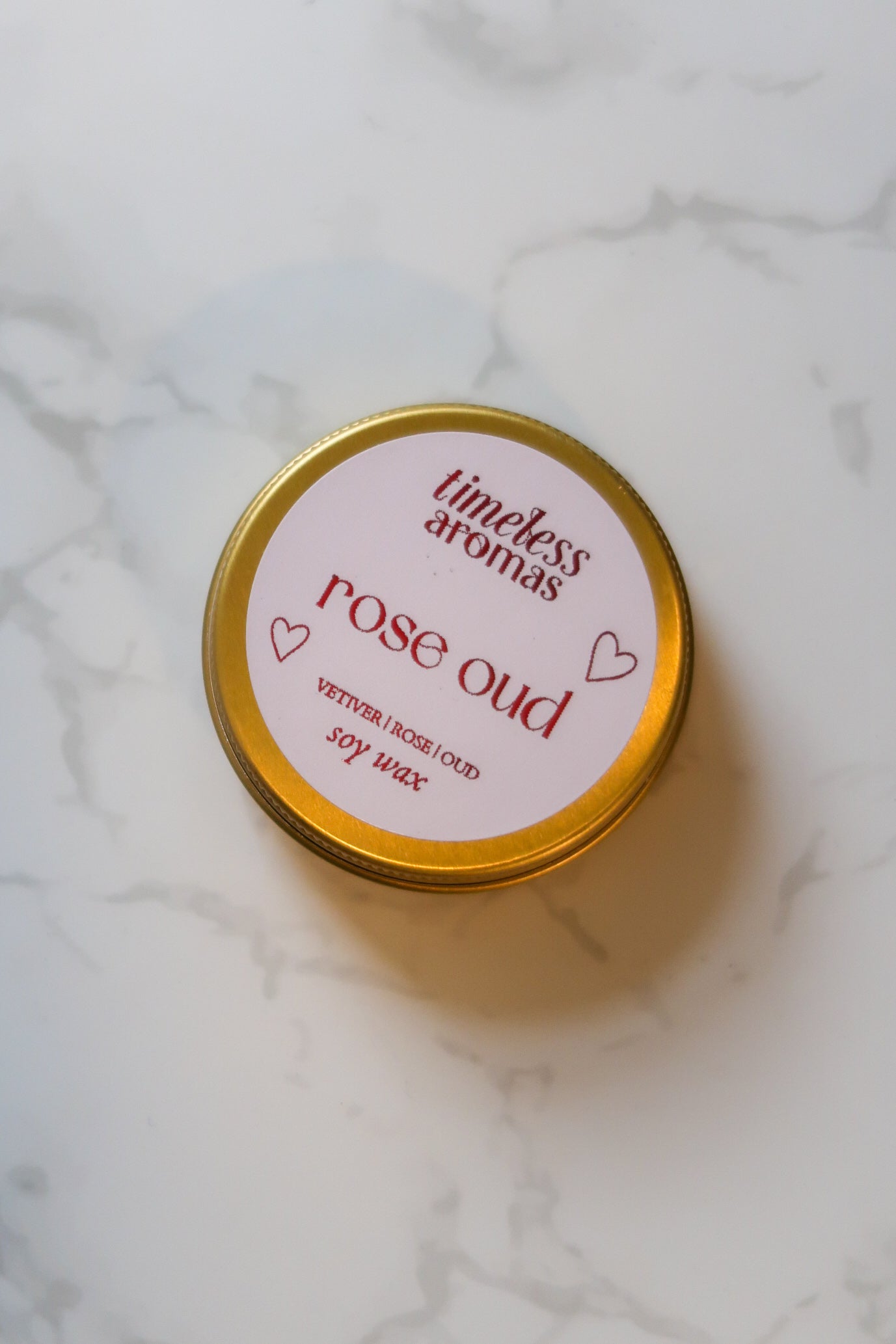 Elegant presentation of the Timeless Aromas Ltd Rose Oud Mini Gold Tin Candle, emphasising its luxurious design and creamy wax, great for romantic evenings and on-the-go use.