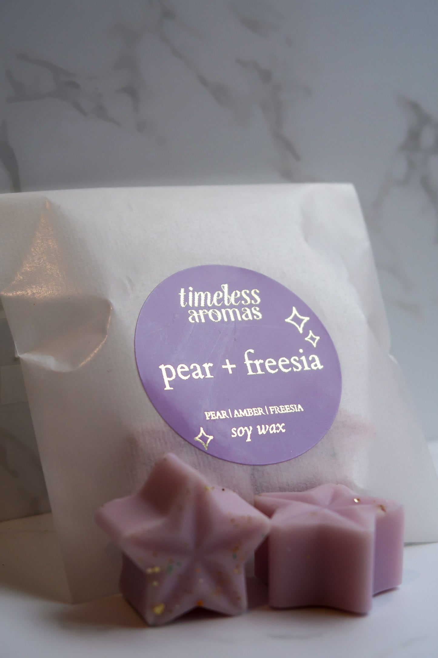 Timeless Aromas Ltd clearance highly scented wax melts - Pear + Freesia, showcasing elegant star-shaped wax melts in soft purple, packaged beautifully for gifting.