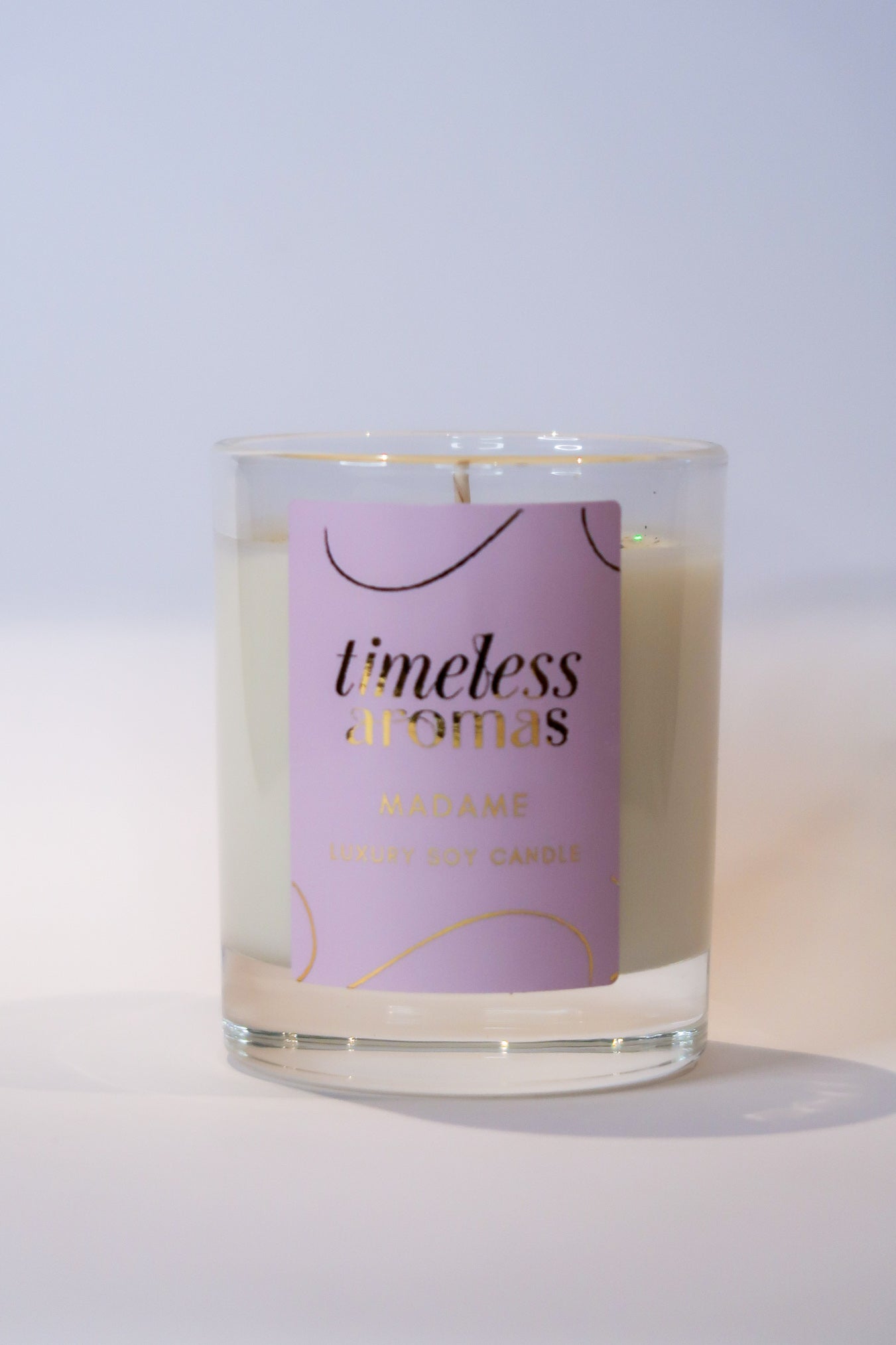 Close-up of the Madame Luxury Scented Candle by Timeless Aromas, highlighting its stylish label and luxurious appearance. Ideal for enhancing your space with a delightful fragrance.