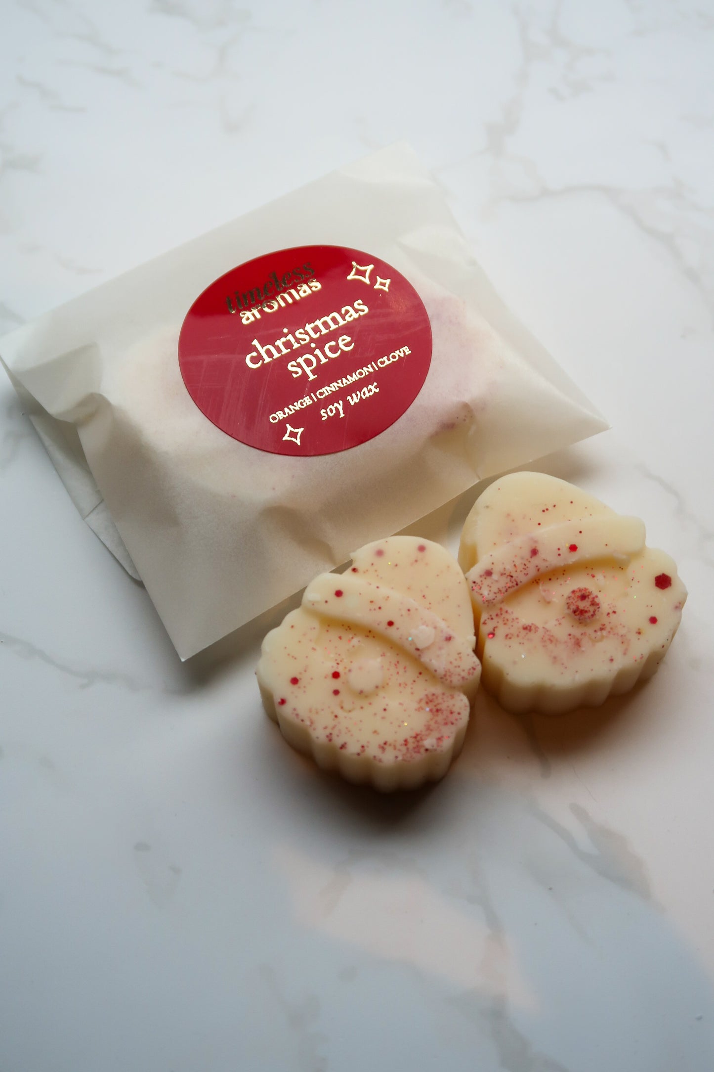 Exquisite Christmas Spice Wax Melts by Timeless Aromas Ltd, featuring two intricately designed Santa-shaped soy wax melts in a luxurious, eco-friendly glassine packet.