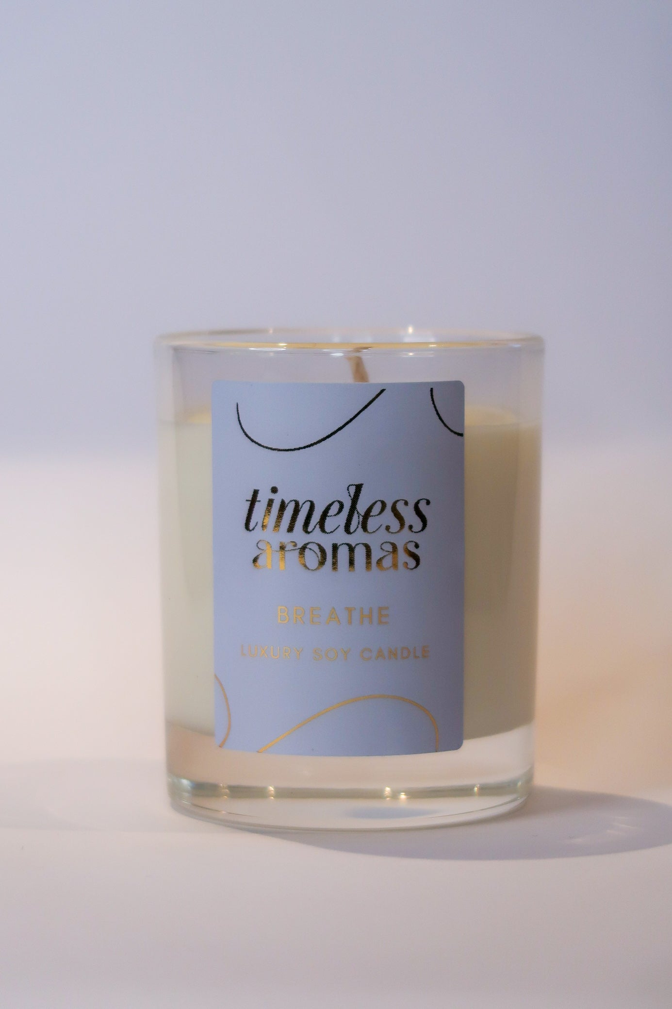 Close-up view of the Breathe luxury scented candle by Timeless Aromas in a clear glass container, highlighting its fresh scents and luxurious design, ideal for brightening any room.