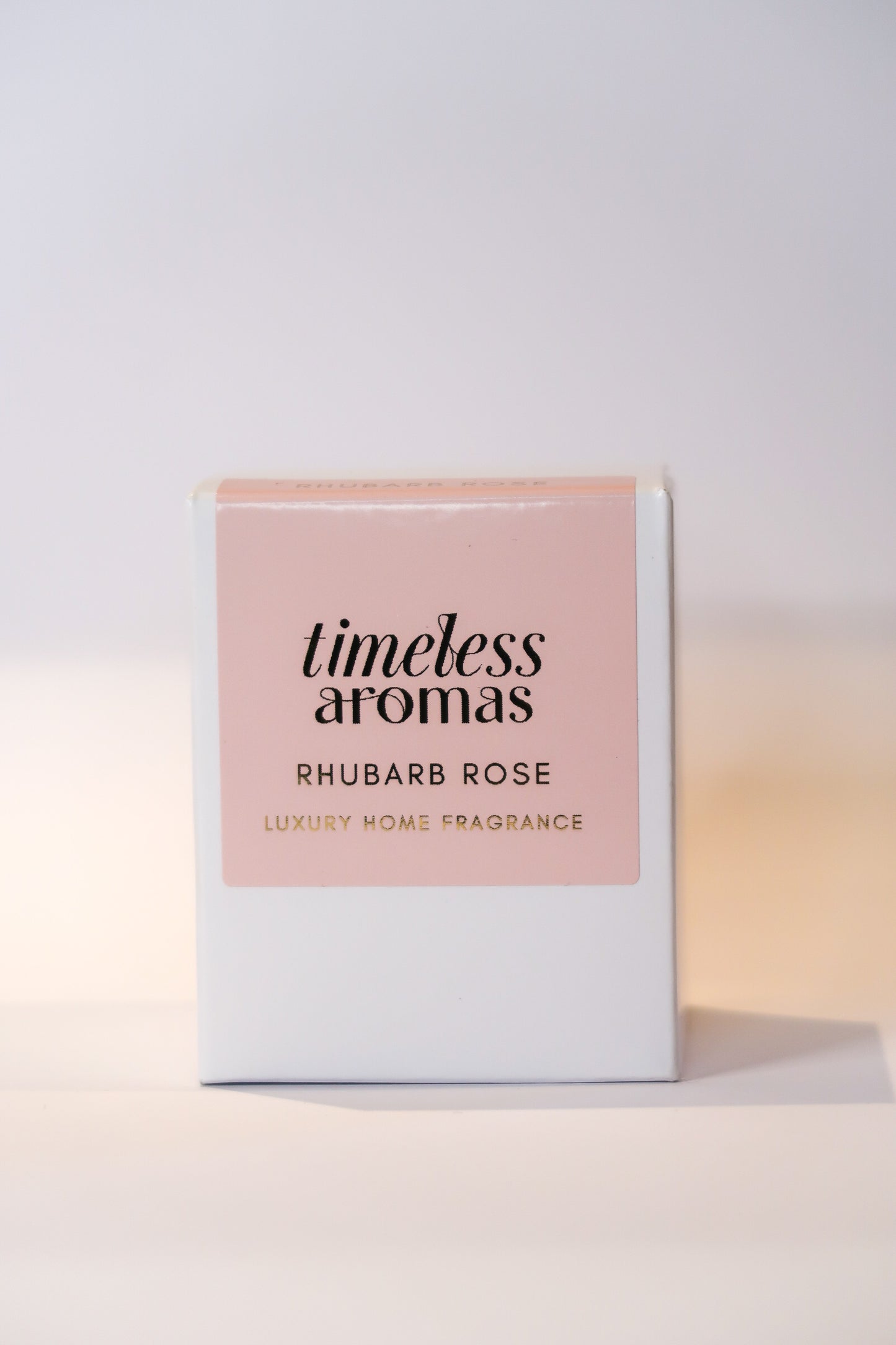 Timeless Aromas Rhubarb Rose Luxury Scented Candle packaging, featuring a pink and gold design. Perfect for highlighting the essence of the rhubarb rose luxury scented candle.