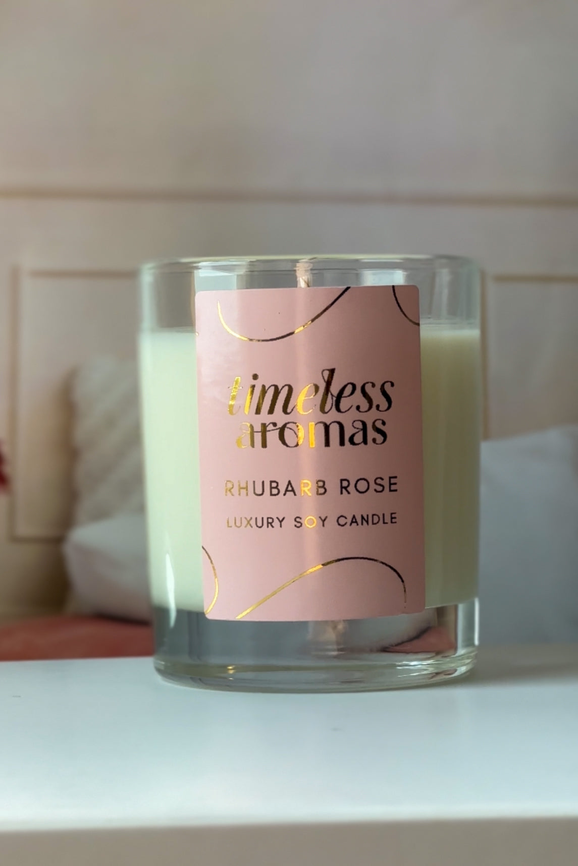 Timeless Aromas Rhubarb Rose Luxury Candle - 200g displayed beautifully, showcasing its elegant design and enticing label. Perfect for adding a charming touch to home decor. Discover the delightful aroma of this rhubarb rose luxury scented candle.