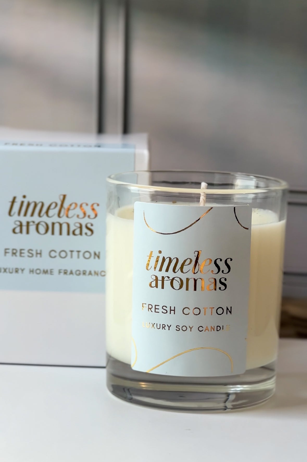 A close-up of Timeless Aromas Fresh Cotton Luxury Scented Candle with its elegant label, representing the soothing and clean aroma associated with a fresh cotton luxury scented candle.