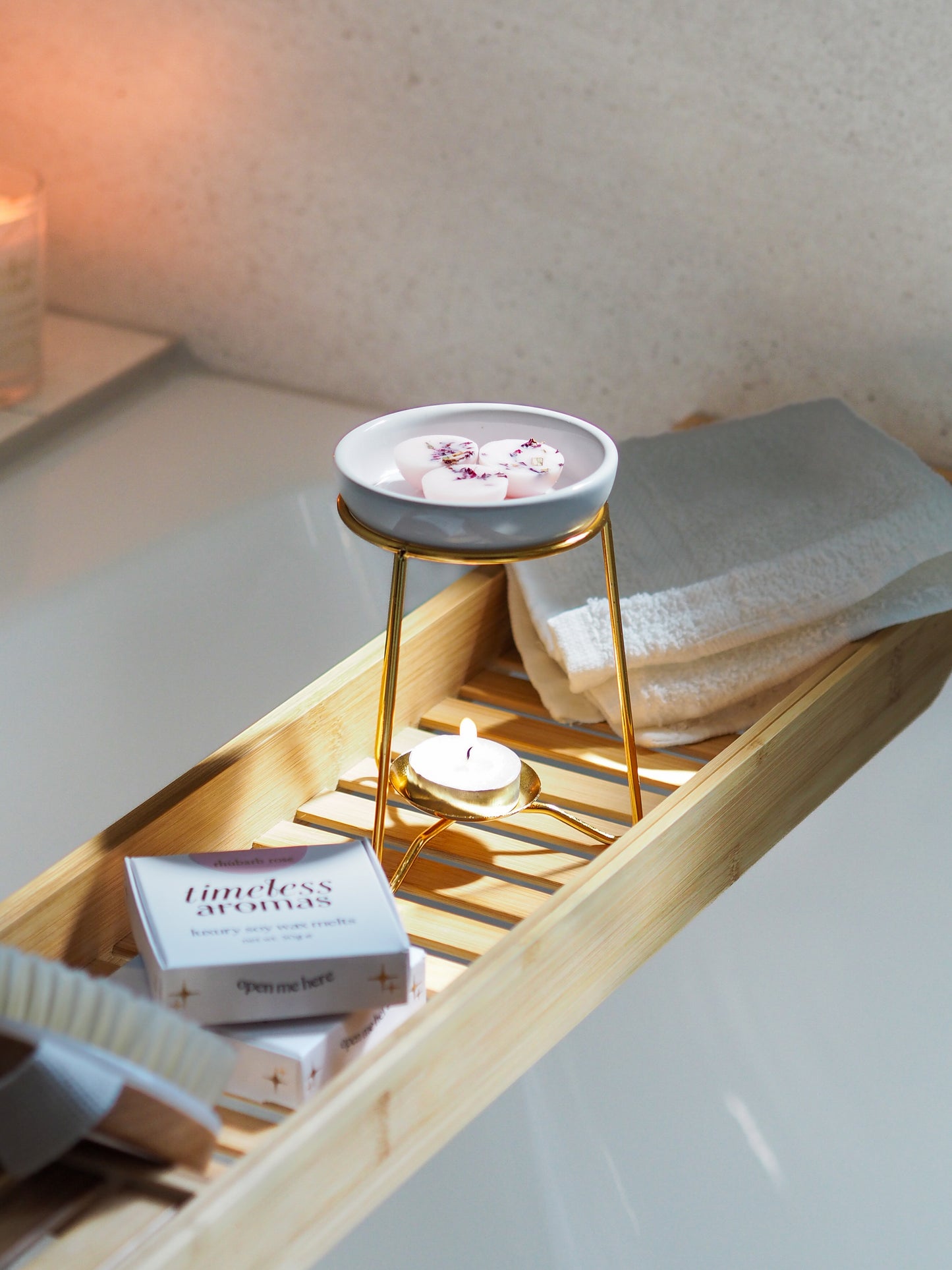An inviting luxury wax melt burner displayed on a bamboo bath tray with tealight candle, designed by Timeless Aromas for a relaxing ambience.
