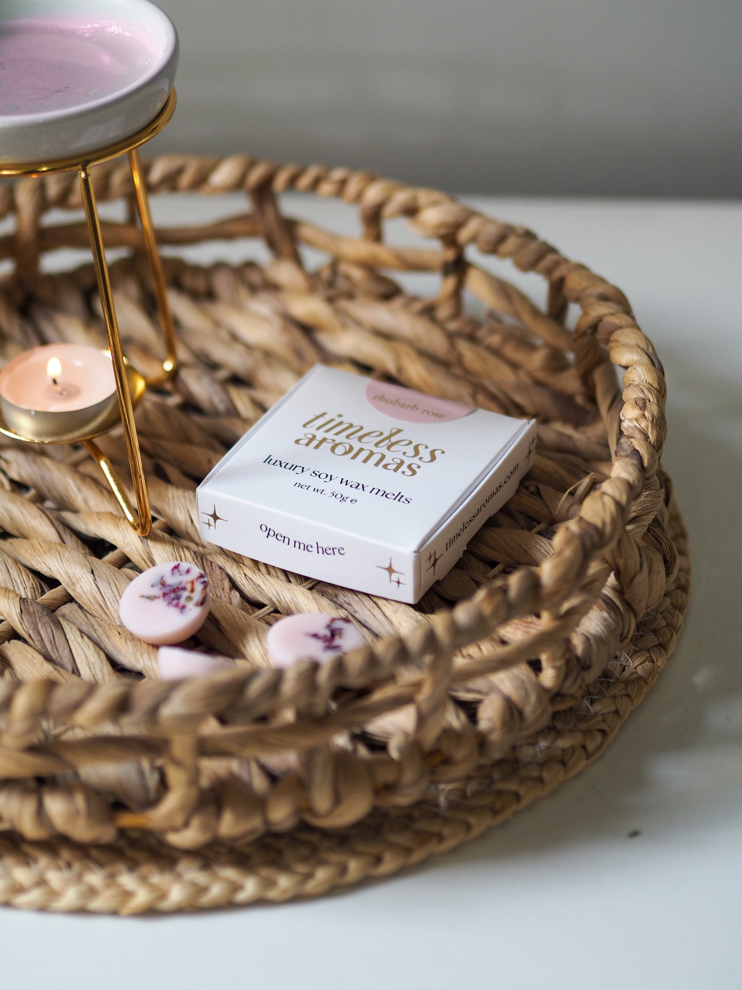 Rhubarb Rose Luxury Wax Melts Box by Timeless Aromas on a decorative tray, showcasing the beautiful packaging and wax melts.