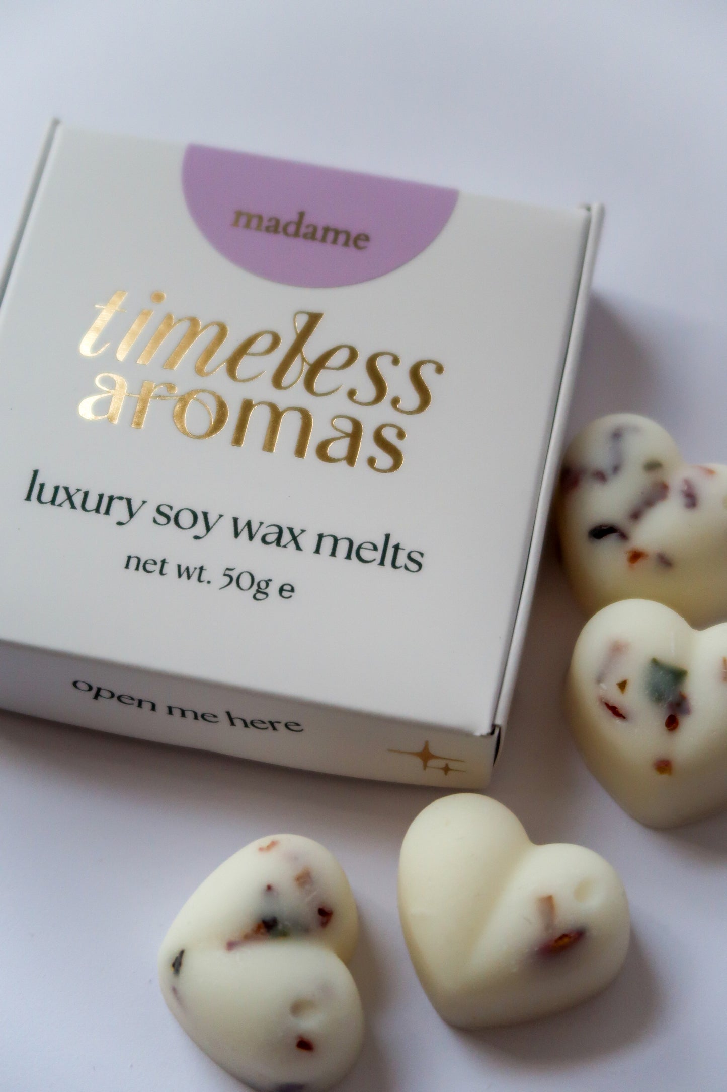 Madame Wax Melt Box featuring Timeless Aromas Ltd, showcasing white, botanical filled heart shaped wax melts with sparkling accents, ideal for filling your home with fragrance.
