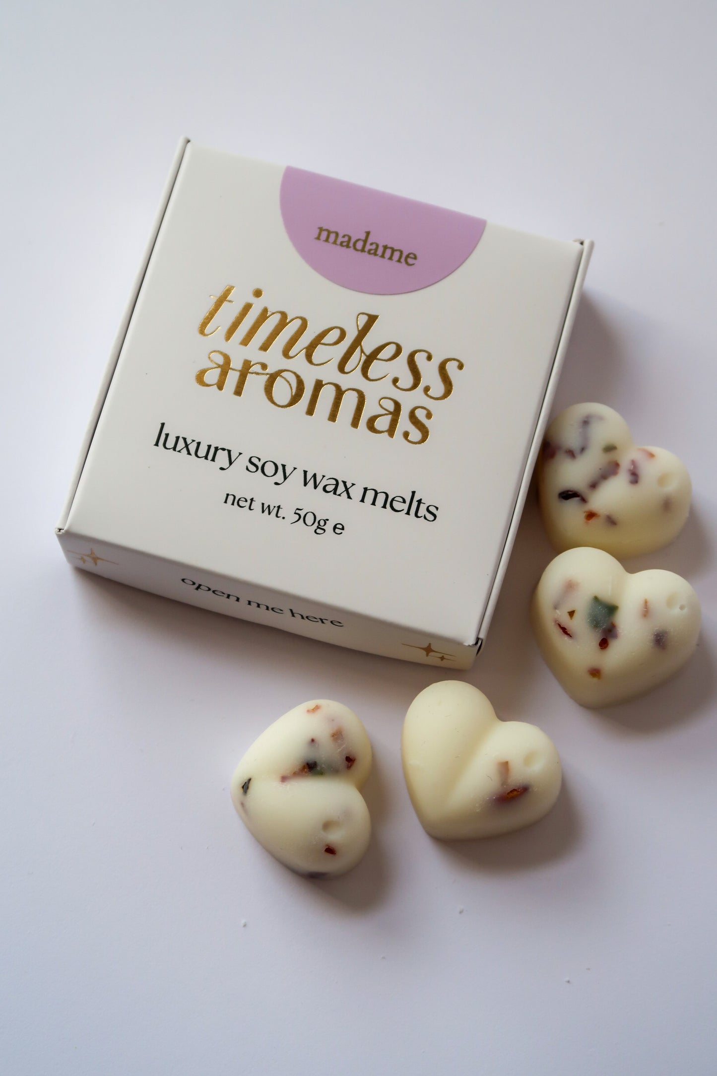 Madame Wax Melt Box featuring Timeless Aromas Ltd, showcasing white, botanical filled heart shaped wax melts with sparkling accents, ideal for filling your home with fragrance.