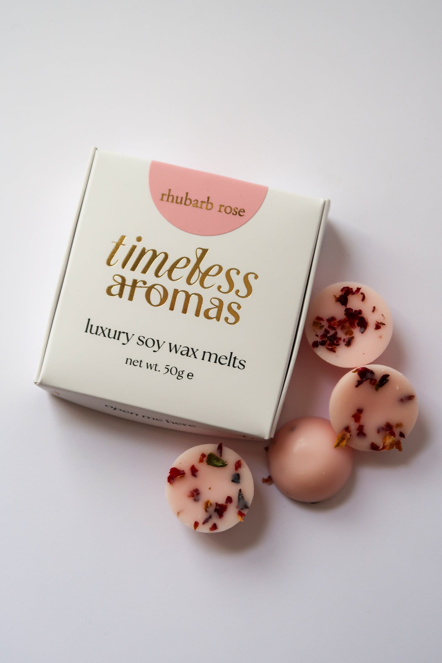 Close-up of Rhubarb Rose Luxury Wax Melts Box by Timeless Aromas with mini dome wax melts, highlighting its elegant packaging and floral details.