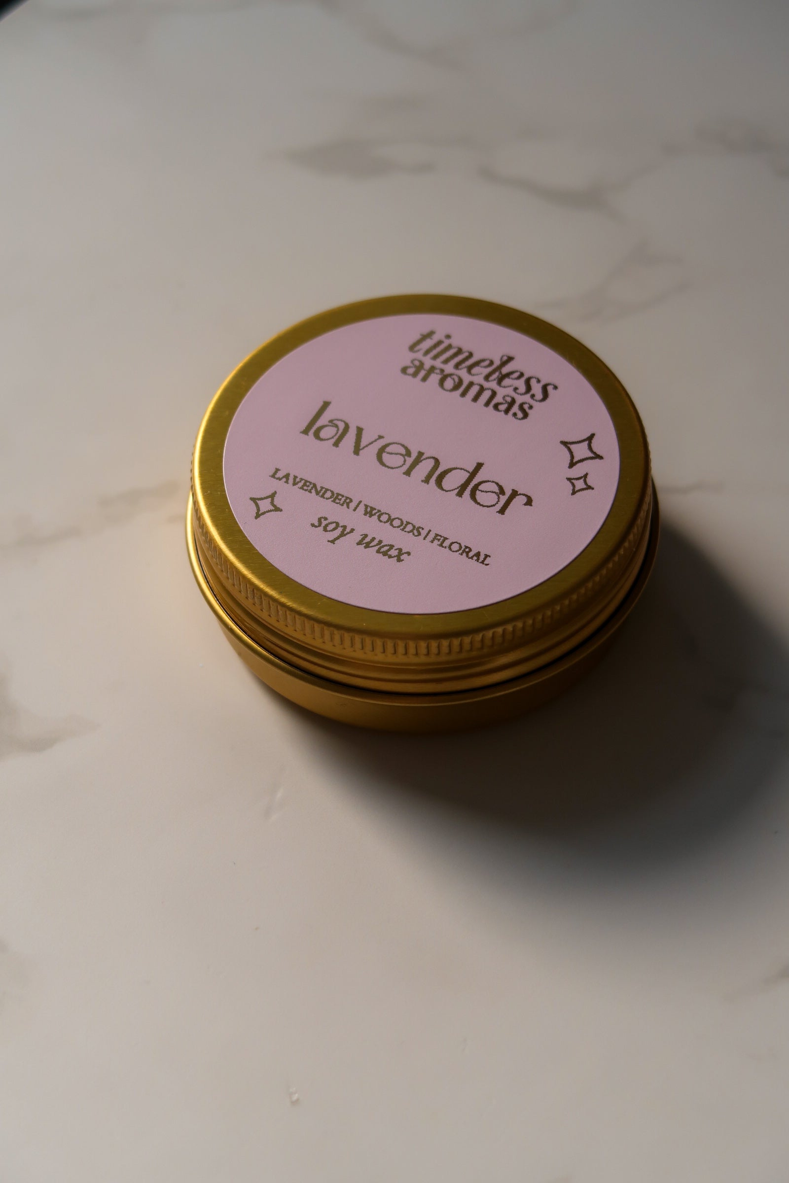Side view of Lavender Mini Gold Tin Candle by Timeless Aromas, highlighting its elegant gold tin design, a perfect addition to any serene space.