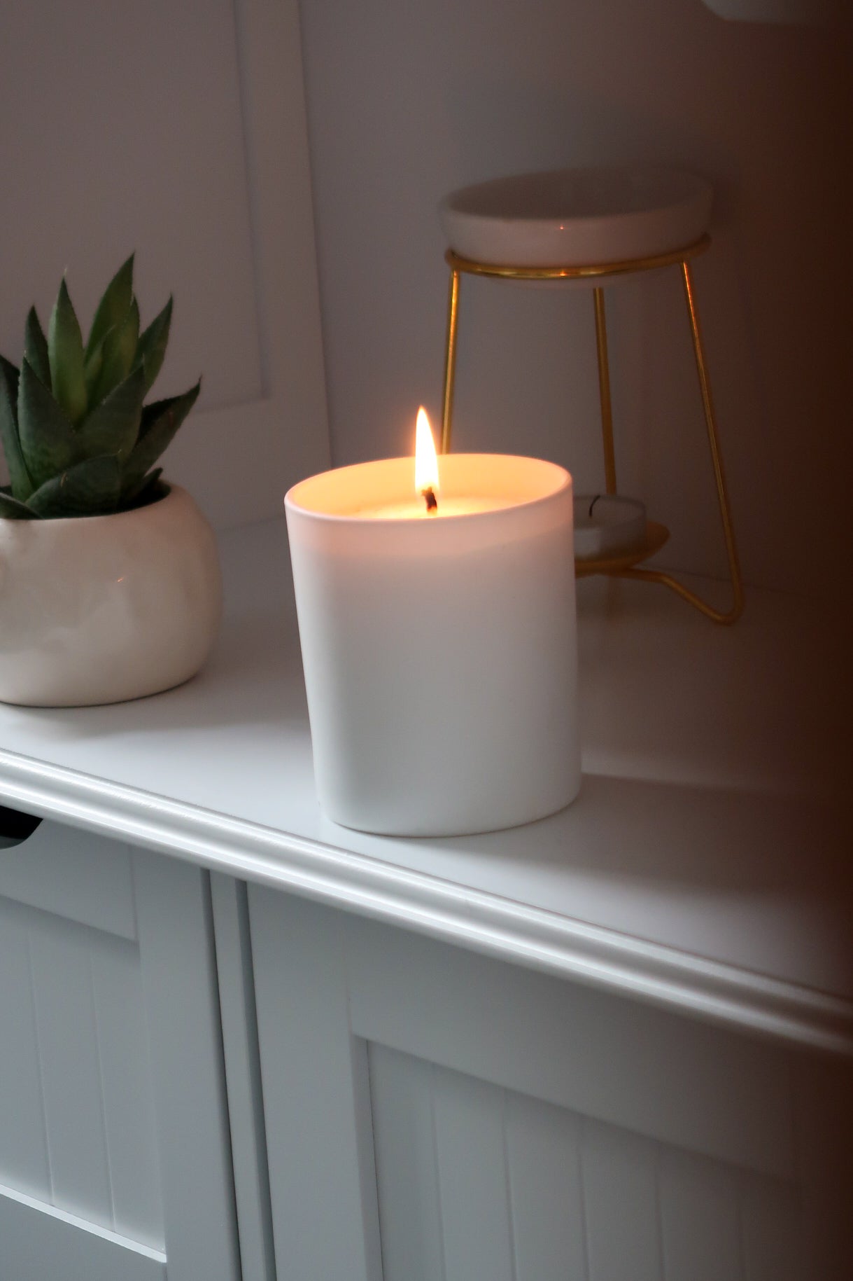 A beautifully lit 30cl White Matte Candle from Timeless Aromas Ltd, exemplifying the quality of hand poured candles for home fragrance. This pack of 6 features a matte ceramic jar design that's perfect for gifts. Blank label candles for businesses 
