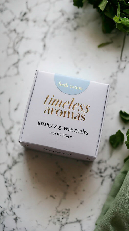 Timeless Aromas fresh cotton luxury wax melt box displayed on a marble surface, perfect for creating a refreshing scent in your home. This box includes 50g of highly fragrant wax melts, ideal for gifting or personal use, featuring the delightful aroma of fresh cotton. Perfect for those who love a clean and refreshing scent, great for a faire atmosphere.