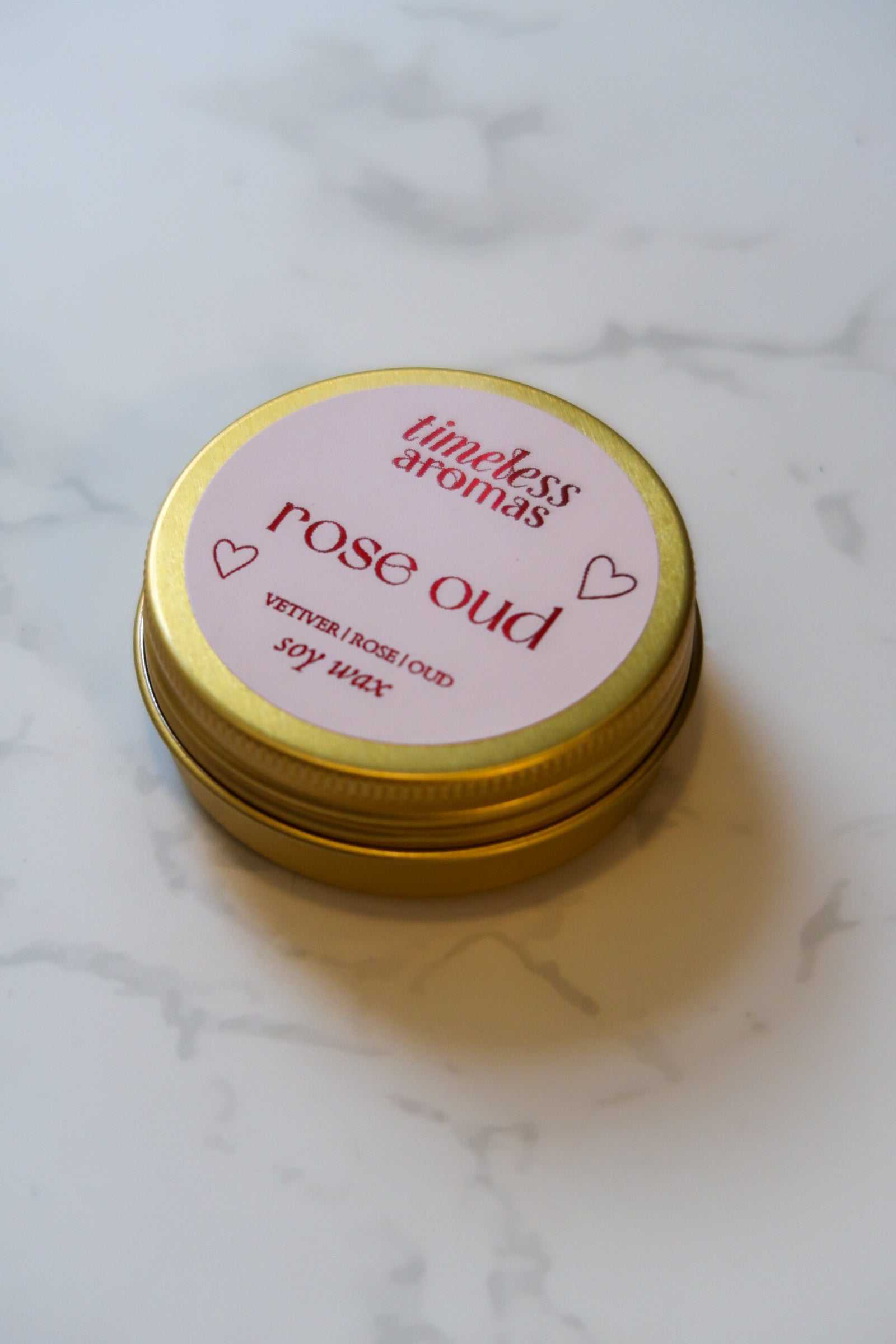 Top perspective of the Timeless Aromas Ltd Rose Oud Mini Gold Tin Candle, beautifully highlighting its elegant gold tin, perfect for creating a romantic atmosphere wherever you go.