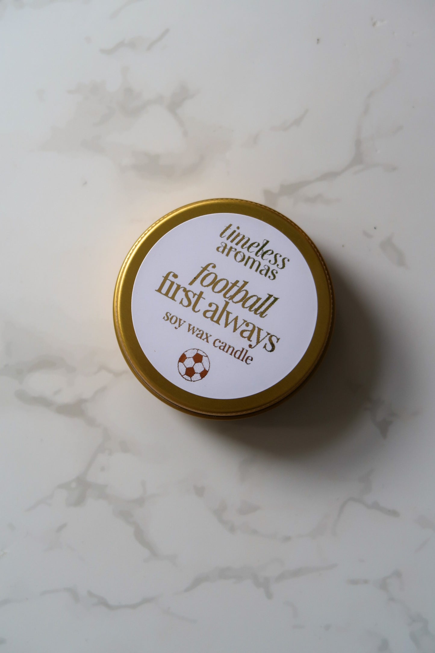 Timeless Aromas Ltd Football First Always Mini Gold Tin Candle, elegantly displayed with a high-quality finish, perfect for football fans. This mini gold tin candle makes an ideal gift for occasions like Father's Day or for followers of Arsenal, Chelsea, or the England World Cup team.