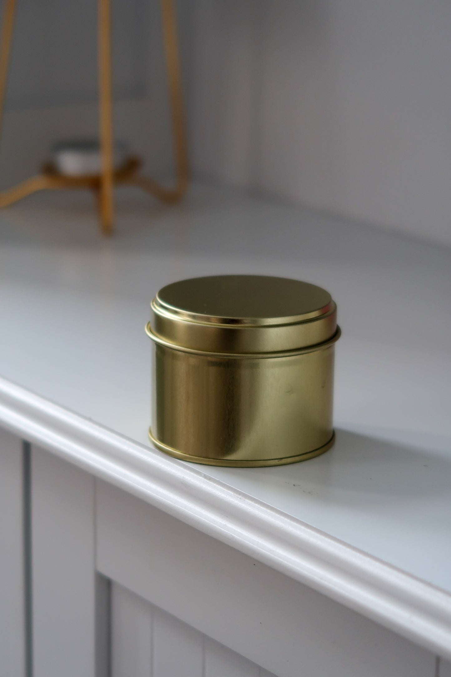 Close up of 100g Gold Tin Candle showcasing the beautiful wax and gold tin design, an exquisite example of hand poured scented candles available in various fragrances. Blank label candles, wholesale candles, white label candles.