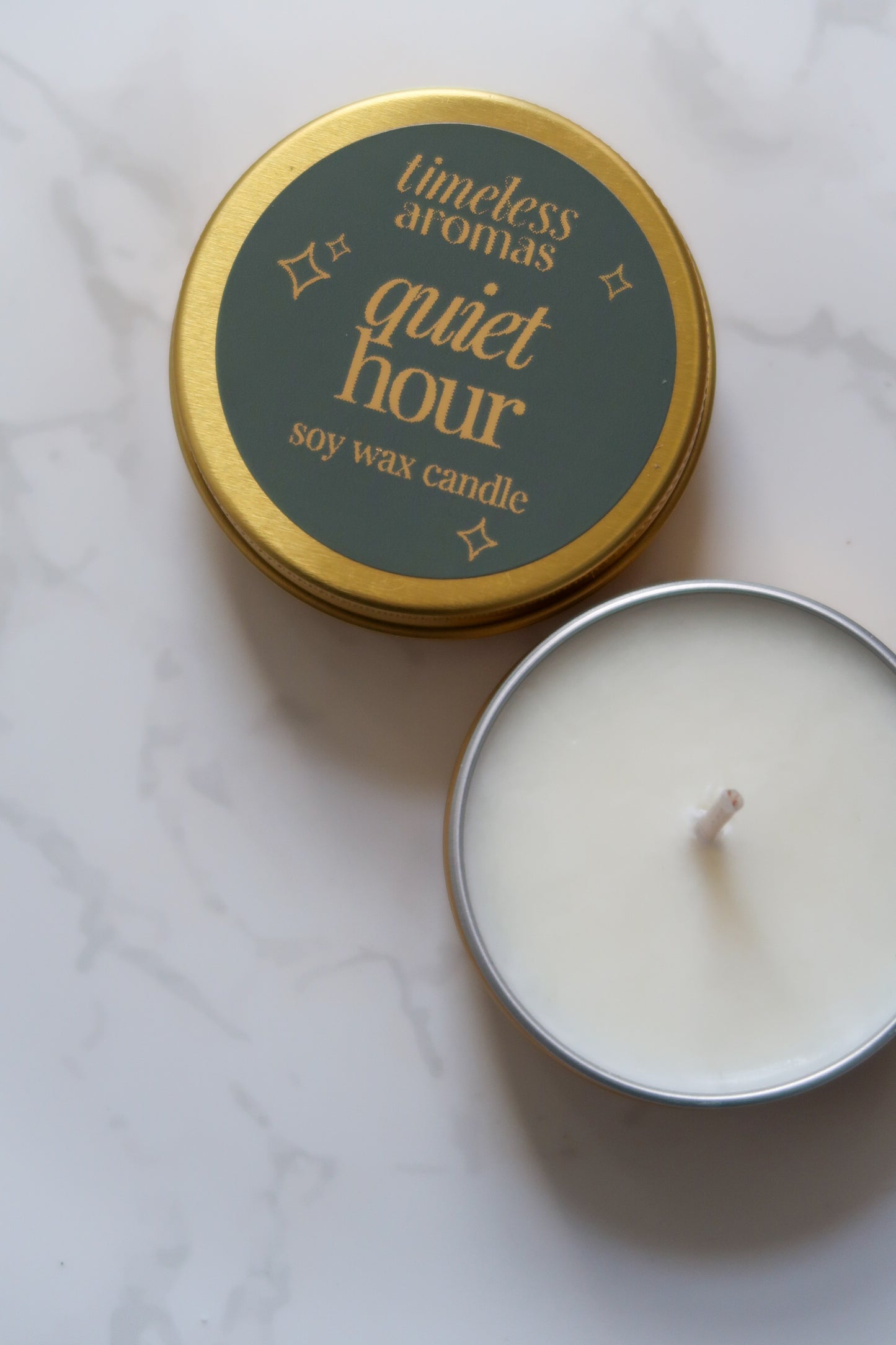 Top view of Timeless Aromas Quiet Hour Mini Gold Tin Candle, highlighting the elegant green label and golden tin.