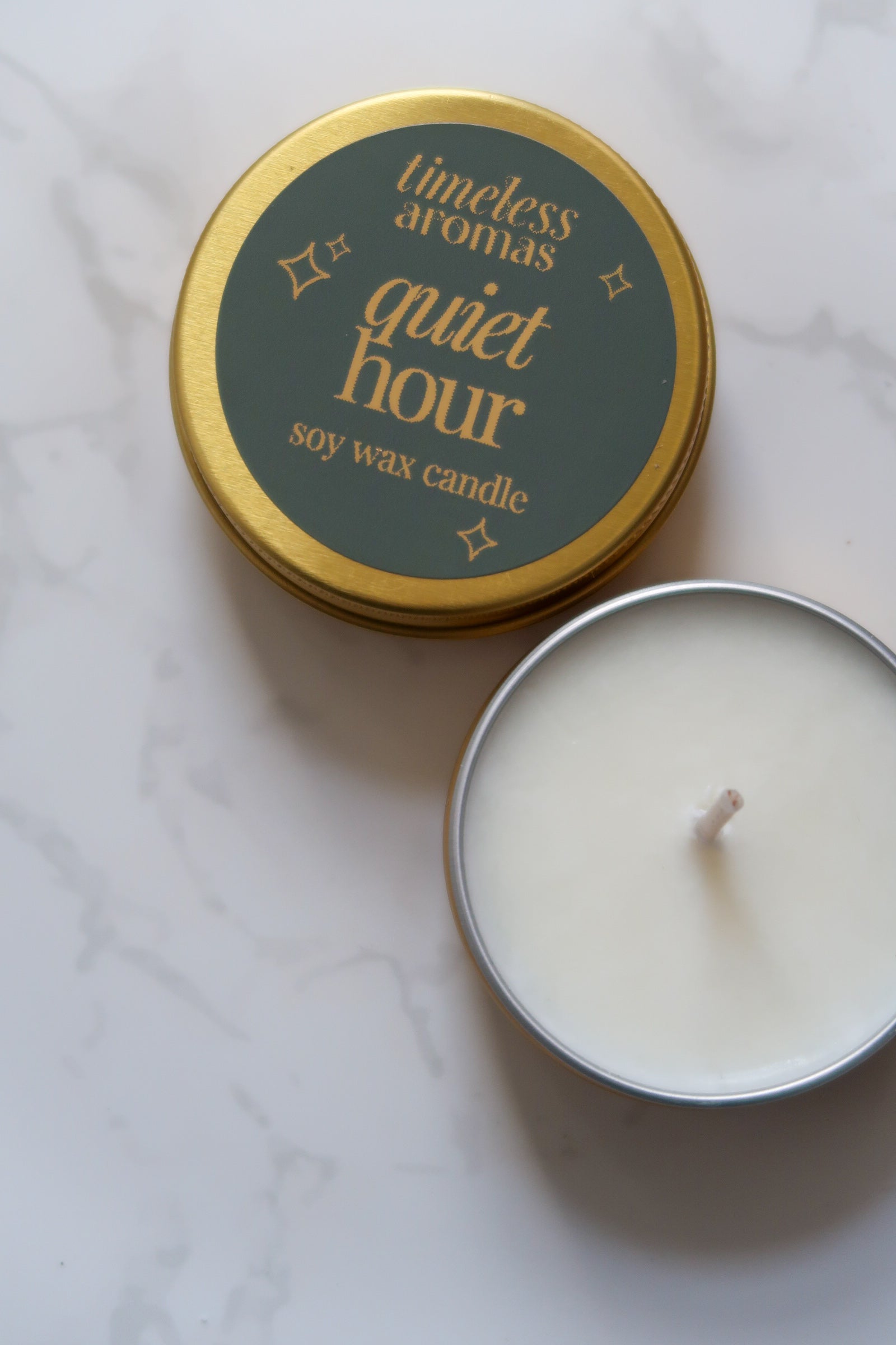 Top view of Timeless Aromas Quiet Hour Mini Gold Tin Candle, highlighting the elegant green label and golden tin.