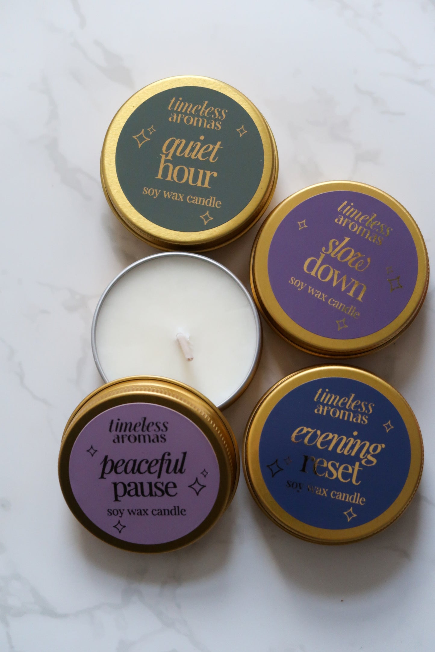 Collection of Timeless Aromas mini gold tin candles including Quiet Hour, showcasing various scents in a luxury tin design.