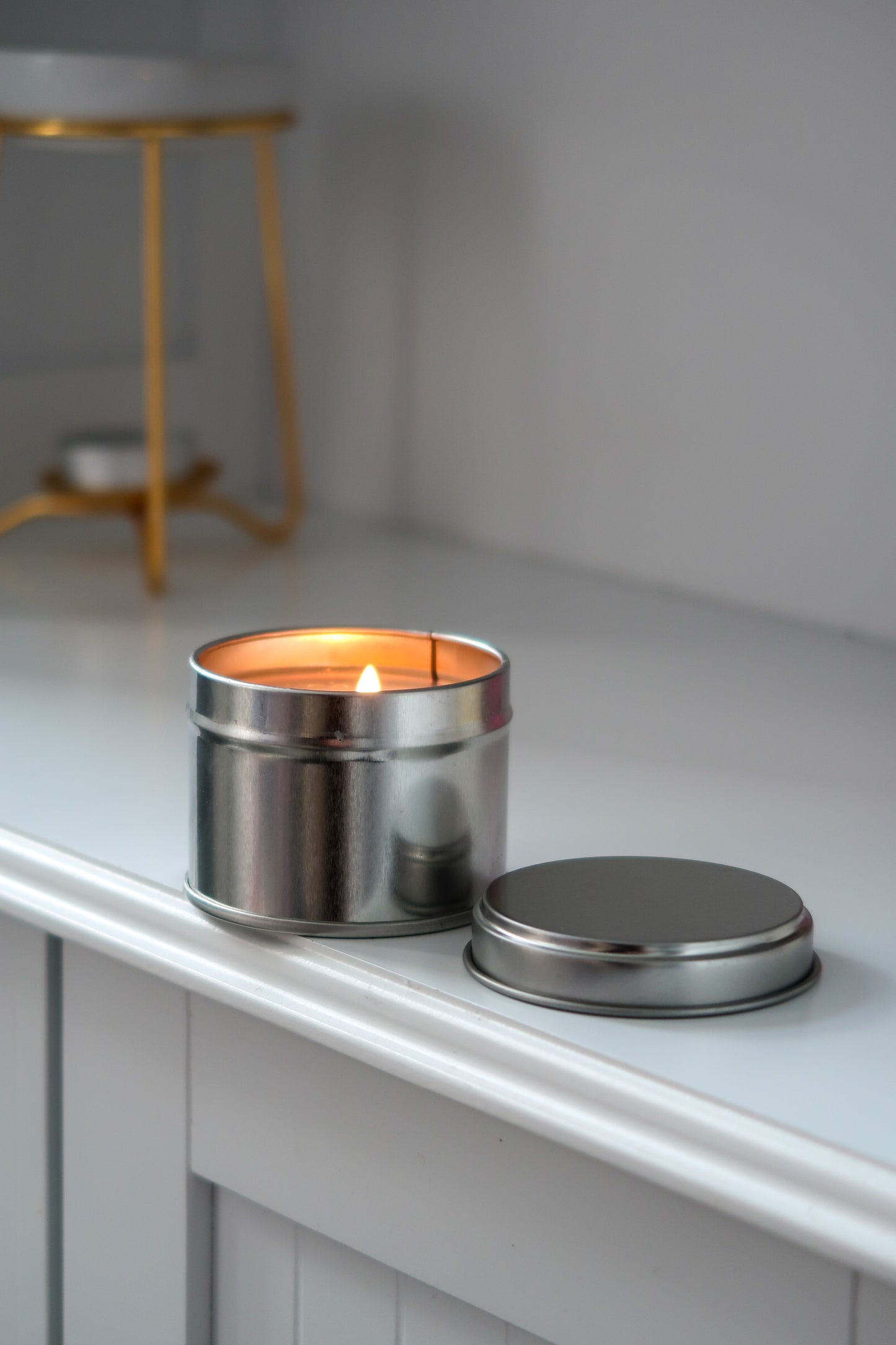 100g Silver Tin Candle from Timeless Aromas Ltd, beautifully showcasing a hand poured candle with a gold lid, perfect for home fragrance. Ideal as a gift, this pack of 6 offers a stylish way to enjoy blank candles, suitable for businesses looking for white label candles.