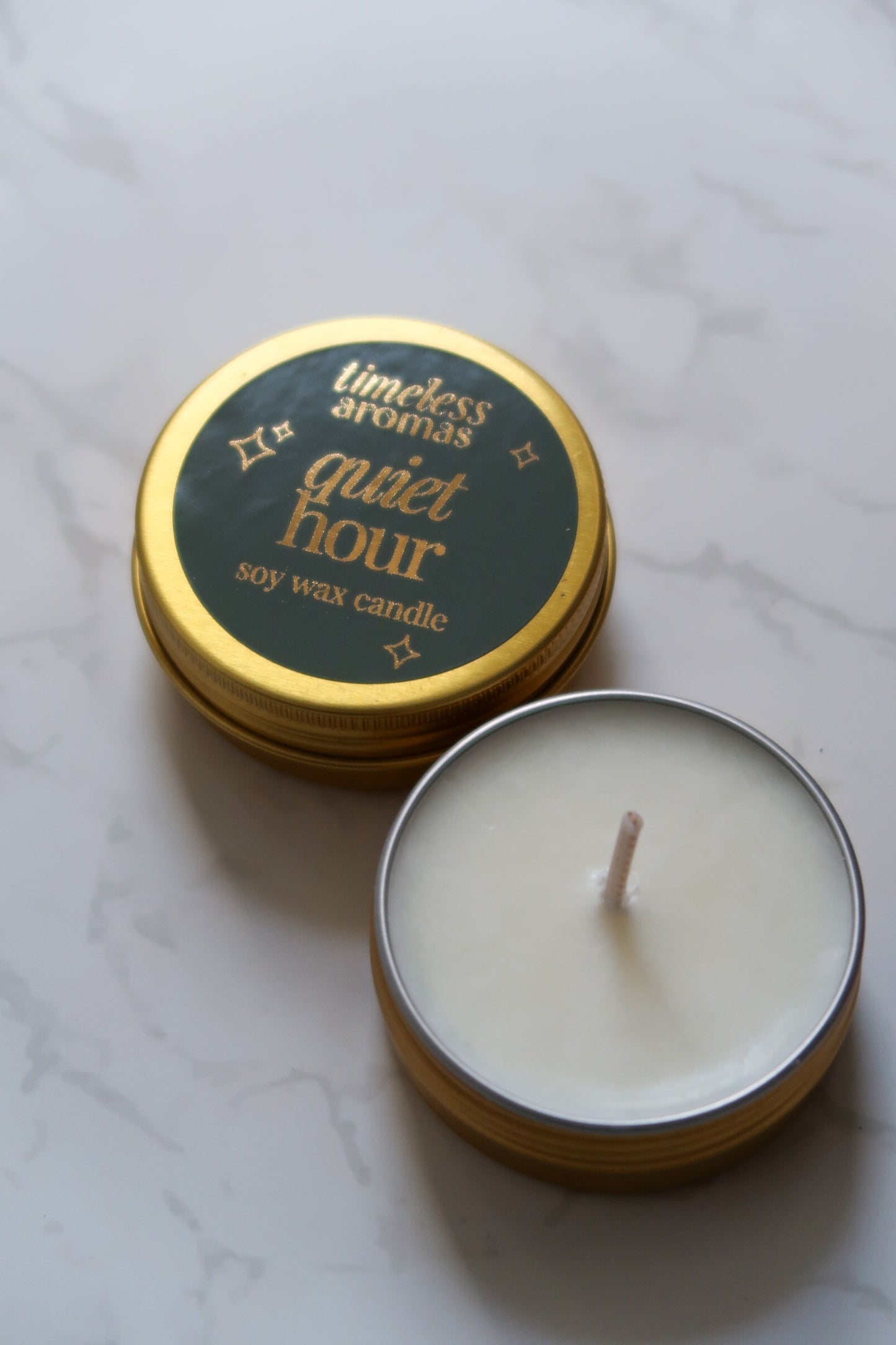 Timeless Aromas Quiet Hour Mini Gold Tin Candle with lid open, showcasing the clean soy wax inside.