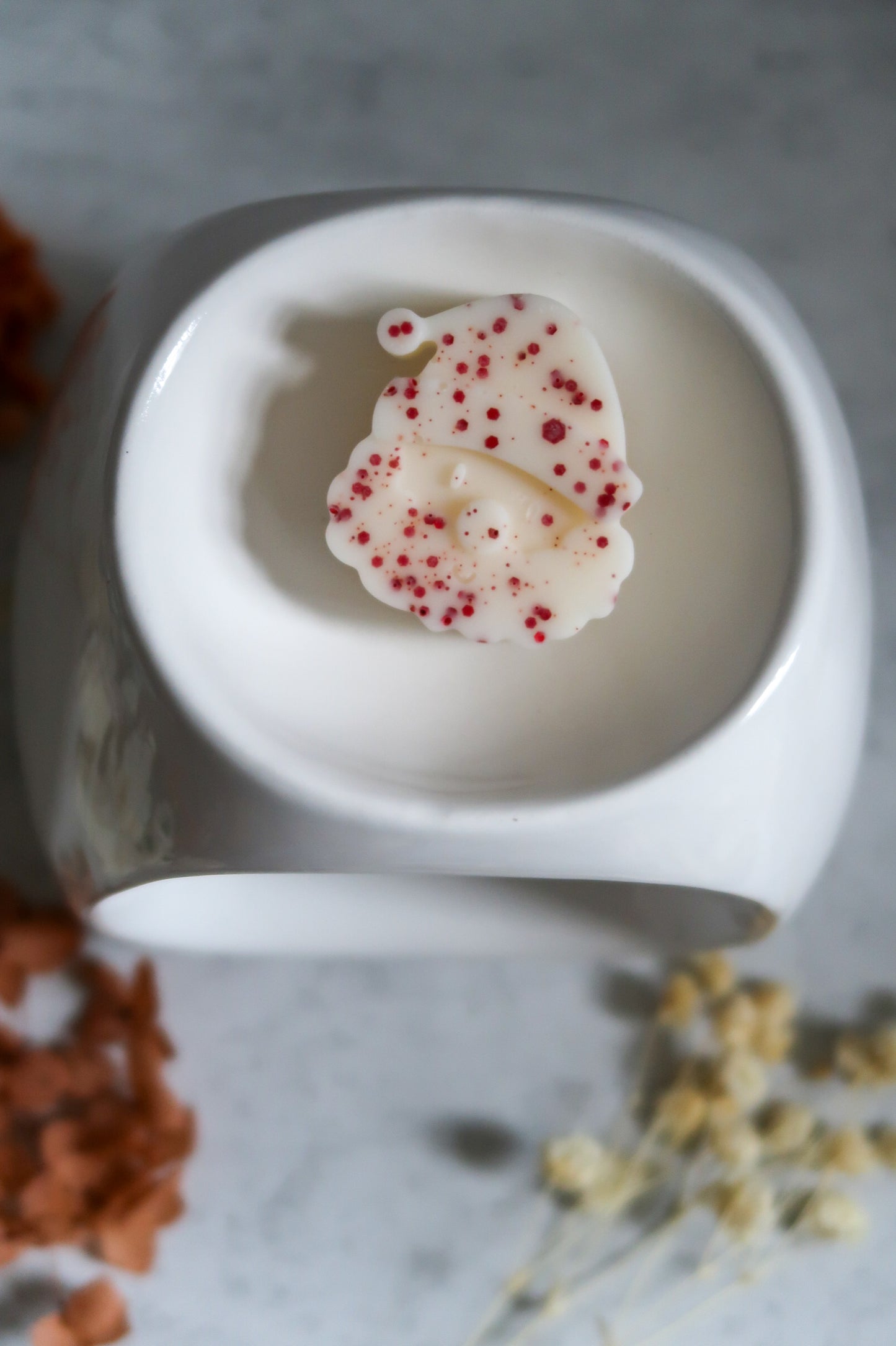 Charming Santa-shaped Christmas Spice Soy Wax Melt by Timeless Aromas Ltd, resting on an elegant warmer, filling the air with a warm, spicy fragrance.