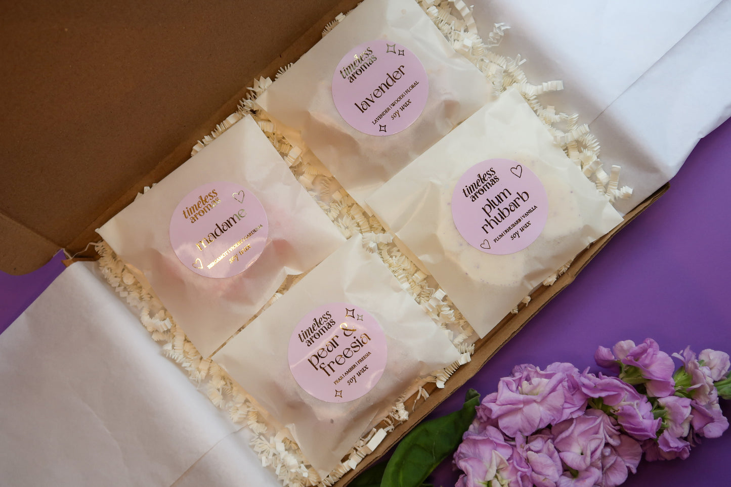 Timeless Aromas Lilac Wax Melt Gift Set featuring assorted wax melts including Plum Rhubarb, Lavender, Pear & Freesia, and Madame in a gift box.