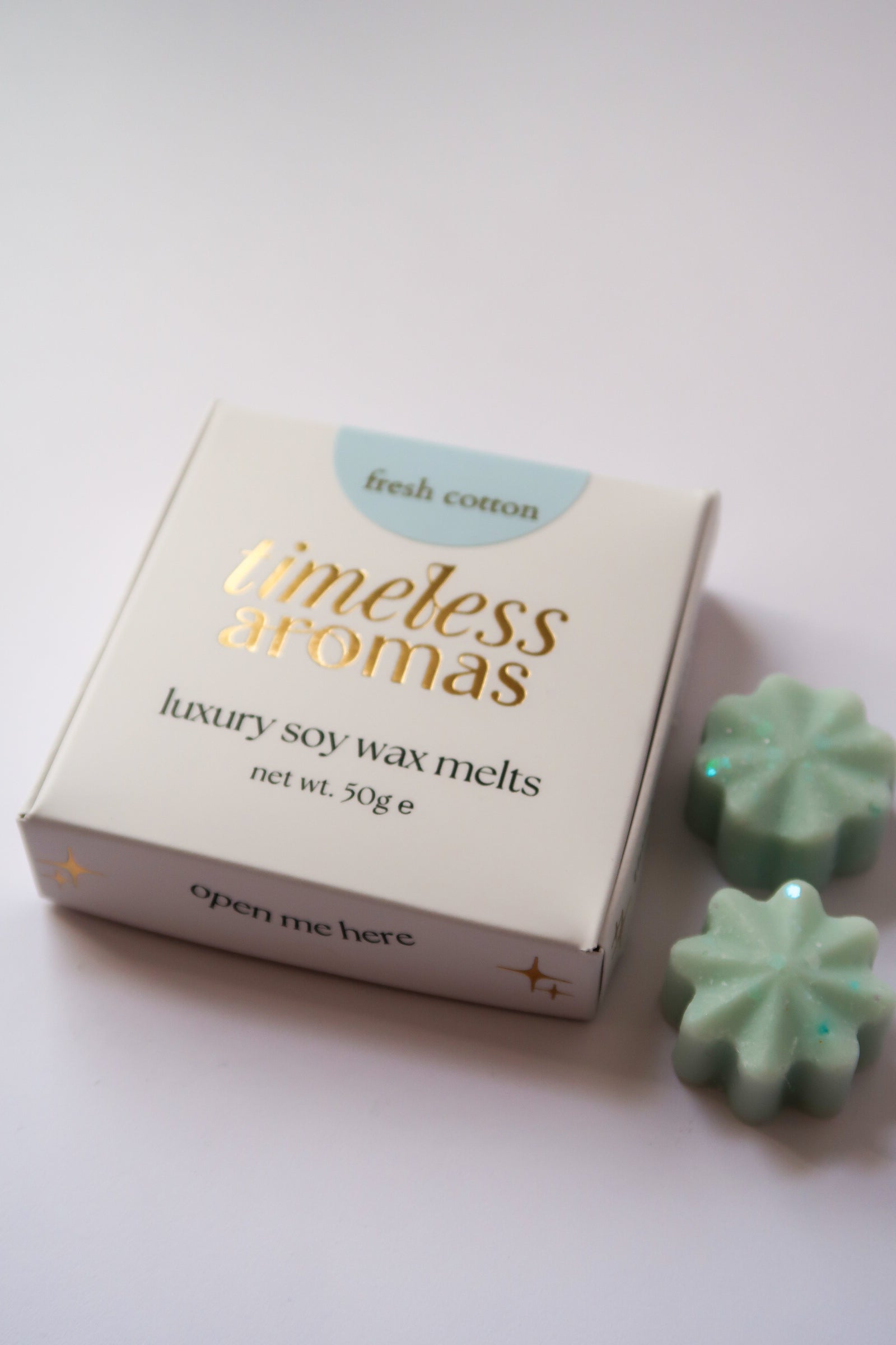 Timeless Aromas fresh cotton luxury wax melt box displayed on a white surface, perfect for creating a refreshing scent in your home. This box includes 50g of highly fragrant wax melts, ideal for gifting or personal use, featuring the delightful aroma of fresh cotton. Perfect for those who love a clean and refreshing scent, great for a faire atmosphere.