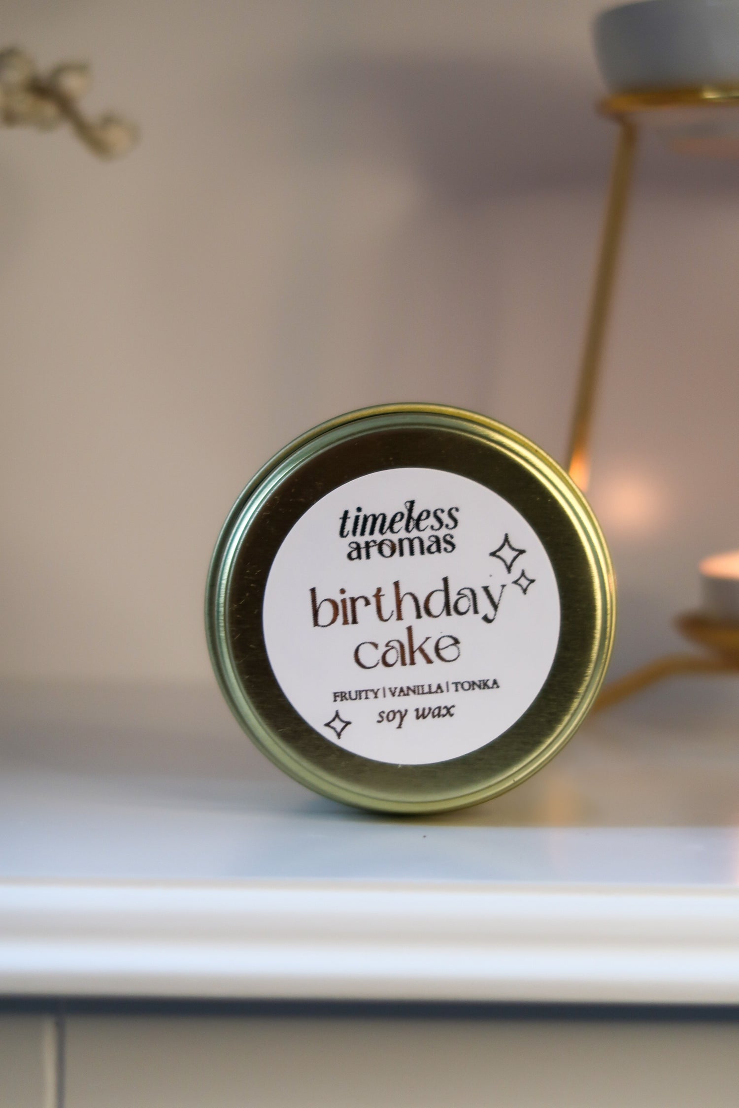 Luxury Gold Tin Candle by Timeless Aromas featuring a 'Birthday Cake' label, showcasing sweet buttercream and vanilla scent, perfect for indulgence. Ideal birthday cake fragrance candle for gifting or personal use.