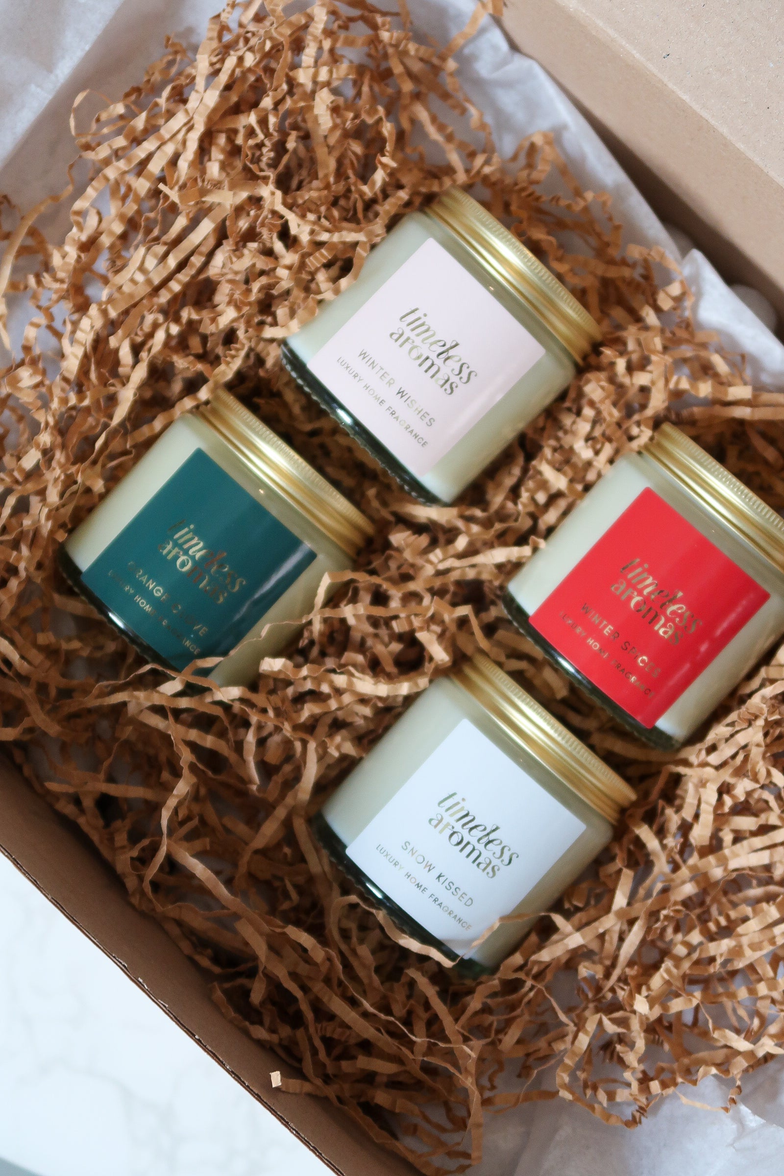Chic presentation of Timeless Aromas Ltd Christmas Candle Gift Set, featuring four premium candles, inviting aromas like Snow Kissed and Winter Spices, to enhance your holiday celebrations with captivating christmas scented candles.