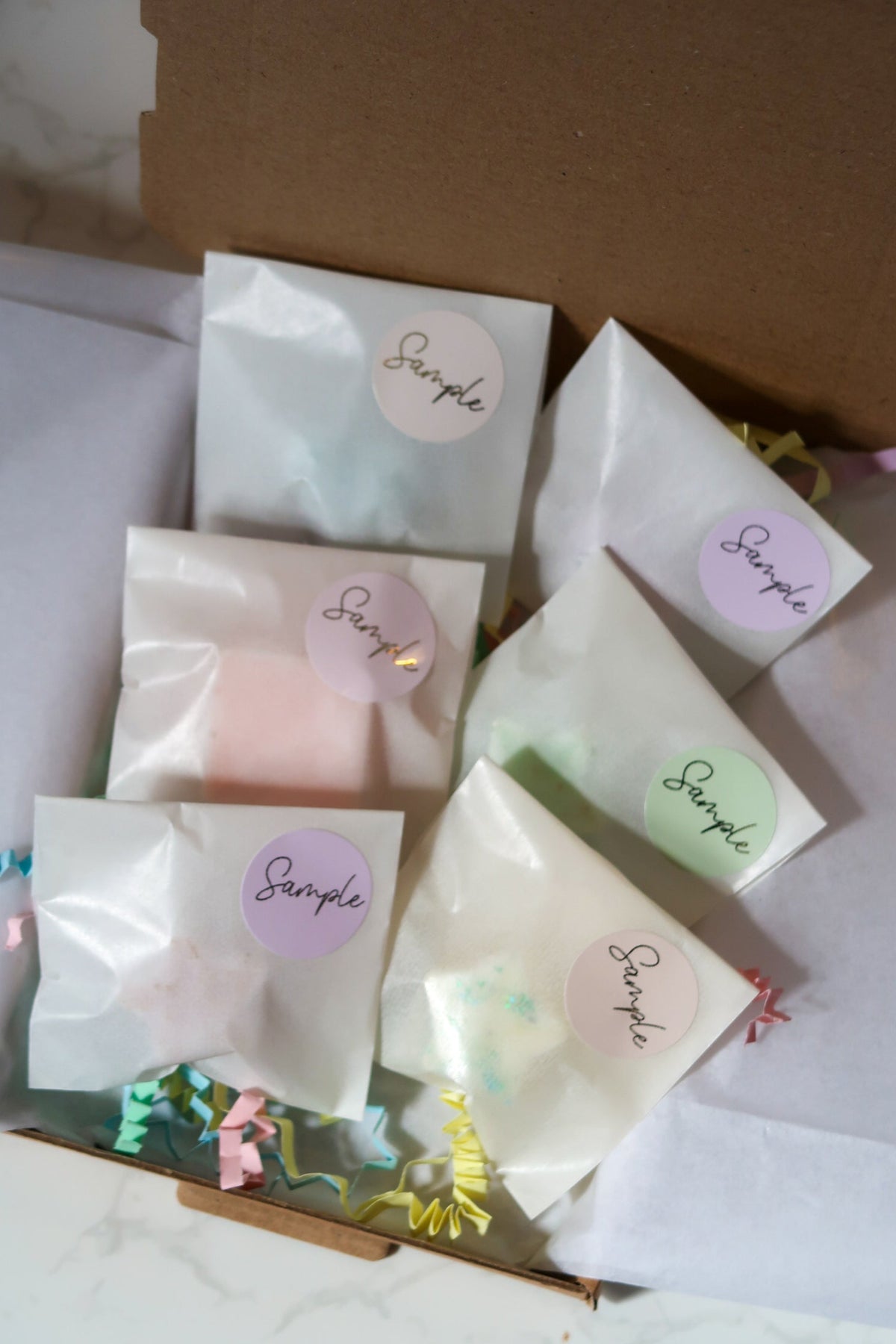 A beautifully arranged Discovery Melt Box by Timeless Aromas Ltd, showcasing individually packaged wax melts in various pastel colours, highlighting the luxurious scents included in the collection.