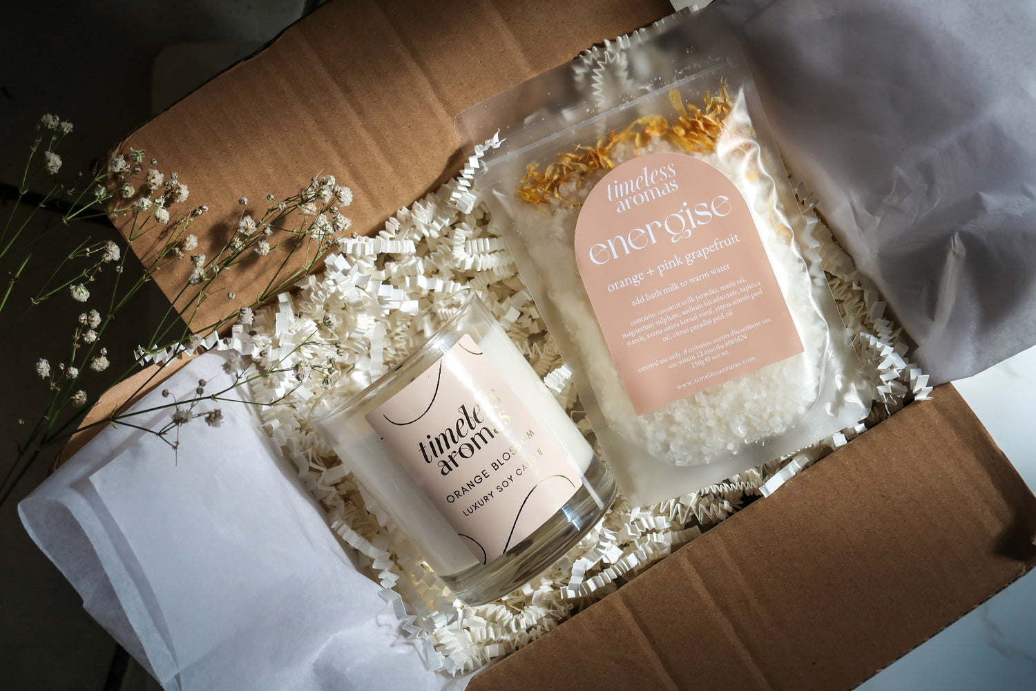 Timeless Aromas Bloom and Energise Gift Set features a 200g orange blossom candle and energise bath milk, creating a delightful home fragrance set with floral orange vibes.